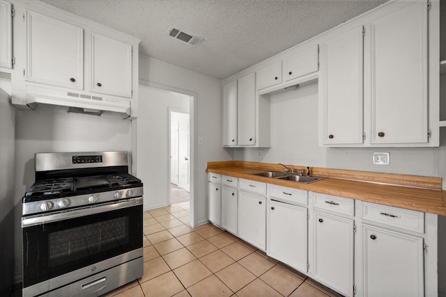 kitchen with under cabinet range hood, a sink, visible vents, white cabinets, and stainless steel gas range