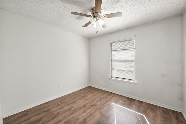 unfurnished room featuring a textured ceiling, wood finished floors, a ceiling fan, and baseboards