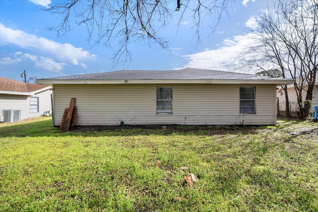 rear view of house featuring a lawn, fence, and central air condition unit