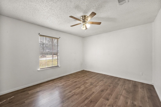 empty room with a ceiling fan, a textured ceiling, visible vents, and wood finished floors