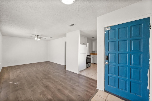 entrance foyer with visible vents, ceiling fan, a textured ceiling, and wood finished floors