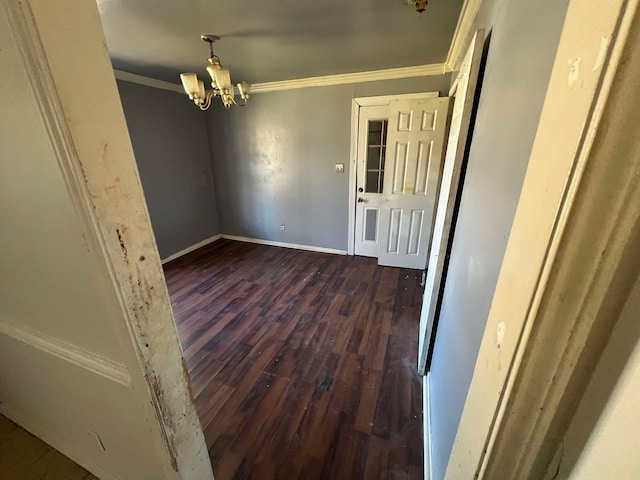 unfurnished room featuring baseboards, ornamental molding, a chandelier, and dark wood-type flooring