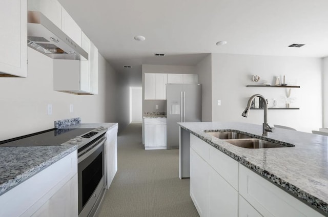 kitchen featuring light stone countertops, extractor fan, stainless steel appliances, white cabinetry, and a sink