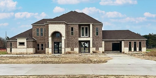 view of front of property featuring driveway and brick siding