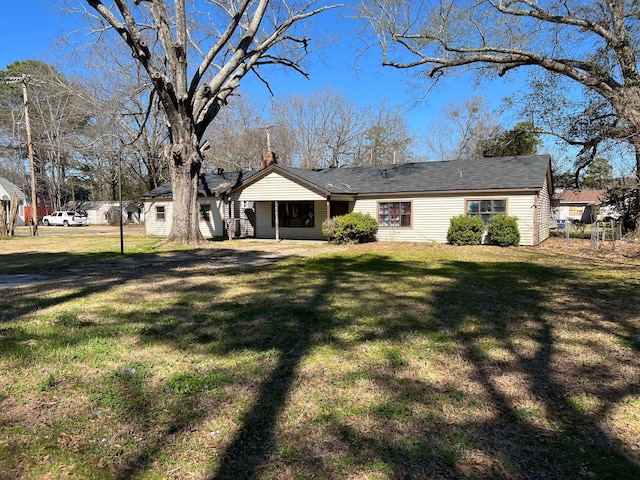 view of front facade with a front lawn and a chimney