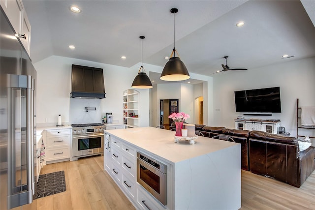 kitchen featuring light wood finished floors, premium range hood, high quality appliances, and arched walkways