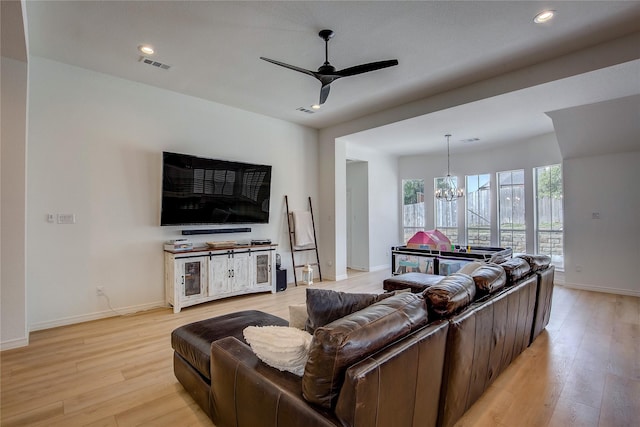 living room with visible vents, baseboards, ceiling fan with notable chandelier, light wood-type flooring, and recessed lighting