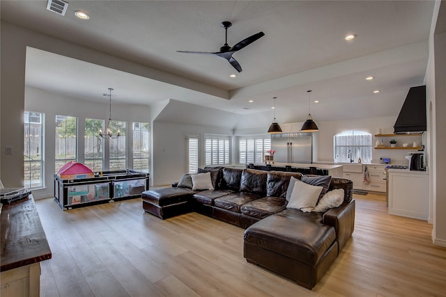 living room with light wood-style floors, ceiling fan with notable chandelier, visible vents, and recessed lighting