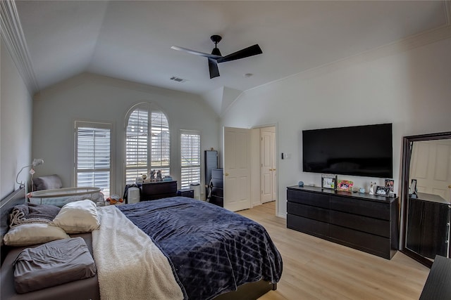 bedroom featuring vaulted ceiling, ornamental molding, and light wood-style flooring
