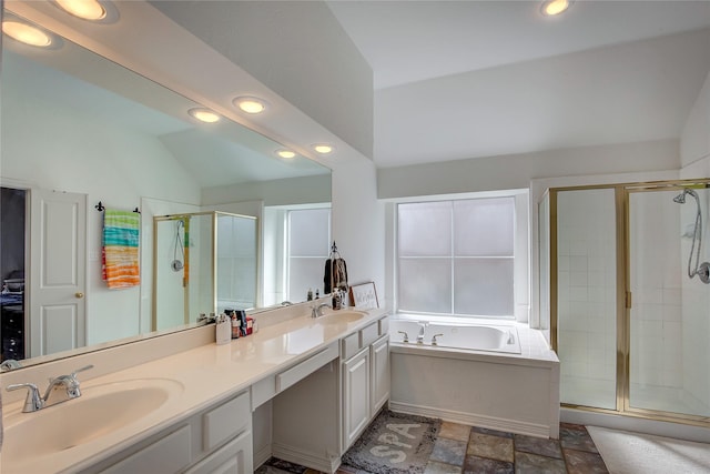 bathroom featuring a sink, vaulted ceiling, a shower stall, a bath, and double vanity