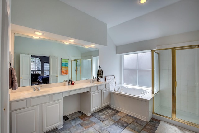 ensuite bathroom with a stall shower, lofted ceiling, ensuite bath, a garden tub, and a sink