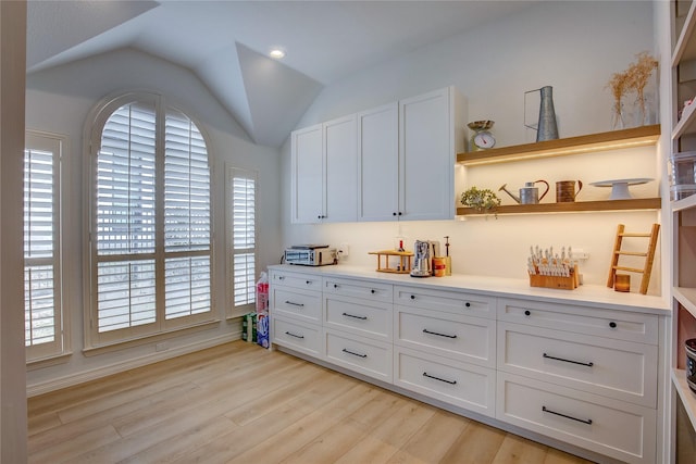 bar featuring vaulted ceiling, light wood-type flooring, and a wealth of natural light
