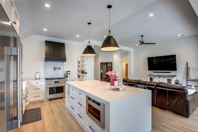 kitchen with light countertops, light wood-style floors, high quality appliances, and custom range hood