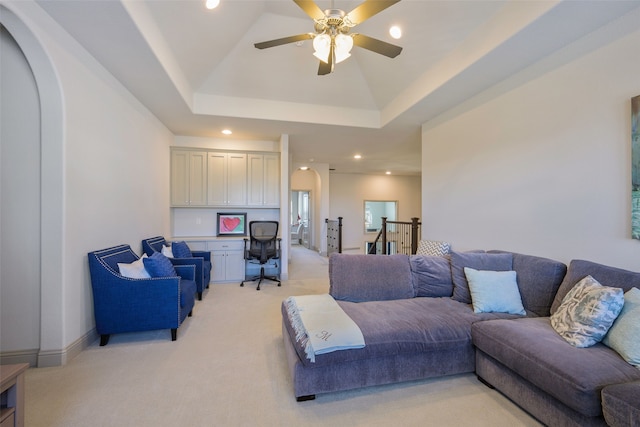 living area featuring arched walkways, built in desk, lofted ceiling, recessed lighting, and light carpet