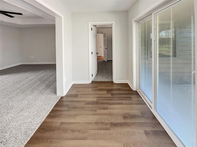 hallway featuring baseboards and wood finished floors