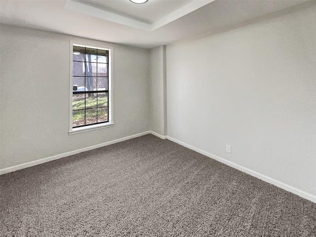 unfurnished room with a raised ceiling and baseboards