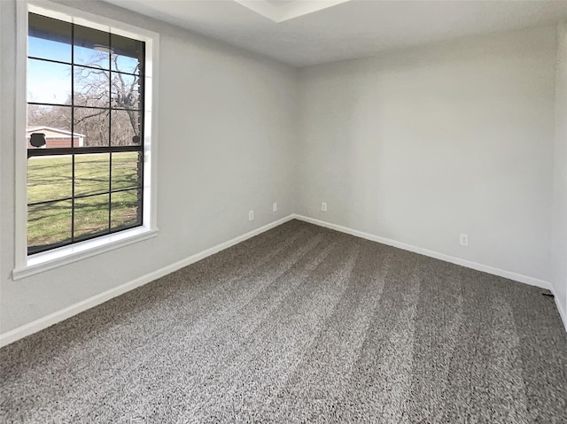 unfurnished room featuring dark carpet and baseboards