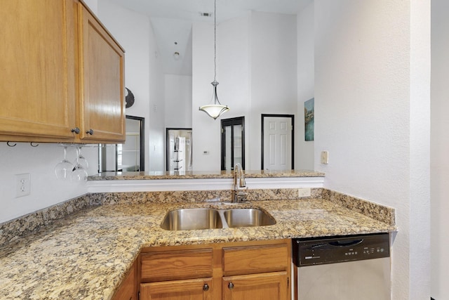 kitchen featuring light stone counters, stainless steel dishwasher, a high ceiling, hanging light fixtures, and a sink