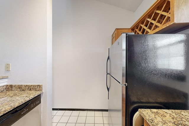 kitchen featuring light tile patterned floors, stainless steel appliances, and light stone counters