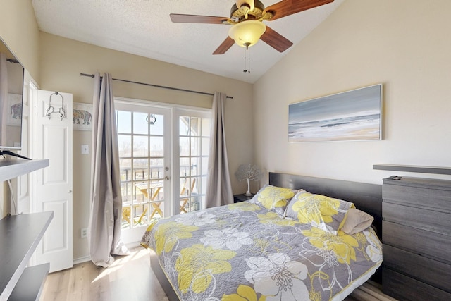 bedroom featuring access to outside, a textured ceiling, wood finished floors, lofted ceiling, and ceiling fan