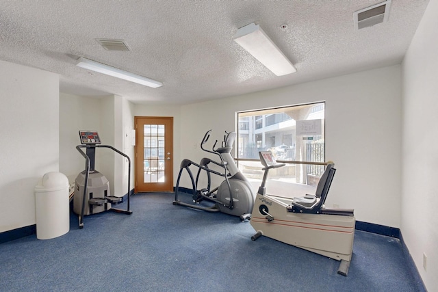 exercise area featuring visible vents, baseboards, and a textured ceiling