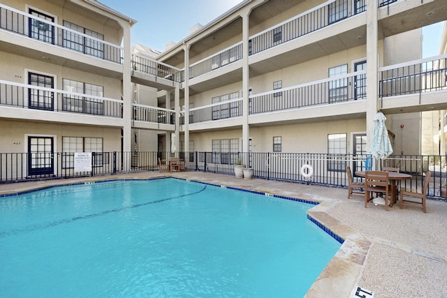 community pool featuring a patio area and fence