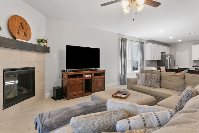 living room with recessed lighting, baseboards, ceiling fan, and a tiled fireplace