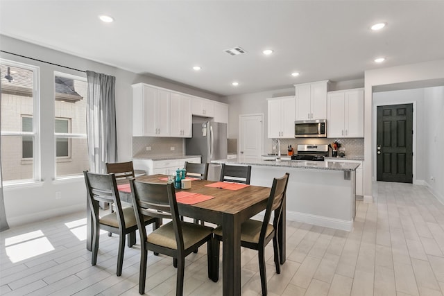 dining area featuring baseboards, visible vents, a wealth of natural light, and recessed lighting