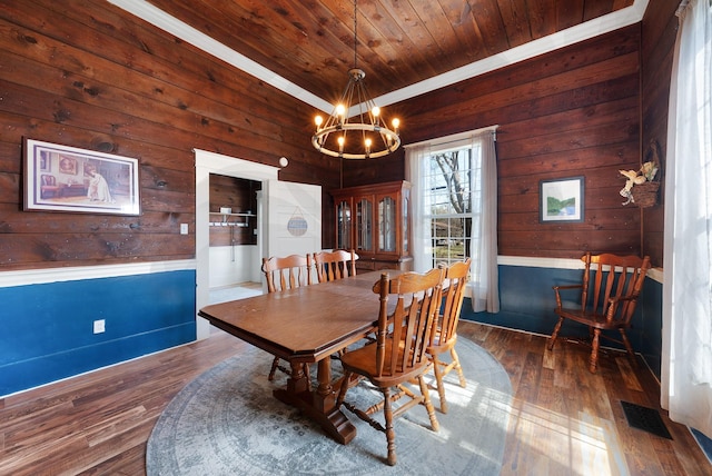 dining room featuring visible vents, wood-type flooring, wooden ceiling, and a chandelier