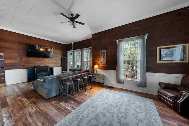1505 Bois D Arc St, Commerce, TX 75428 - living room featuring wooden walls, a ceiling fan, healthy amount of natural light, hardwood / wood-style flooring, and a wainscoted wall