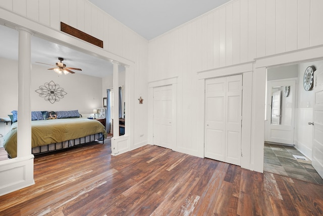 bedroom with wood finished floors, ceiling fan, and decorative columns