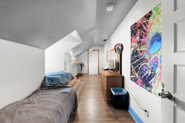 bedroom featuring hardwood / wood-style flooring and vaulted ceiling