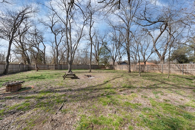 view of yard featuring a fire pit and a fenced backyard