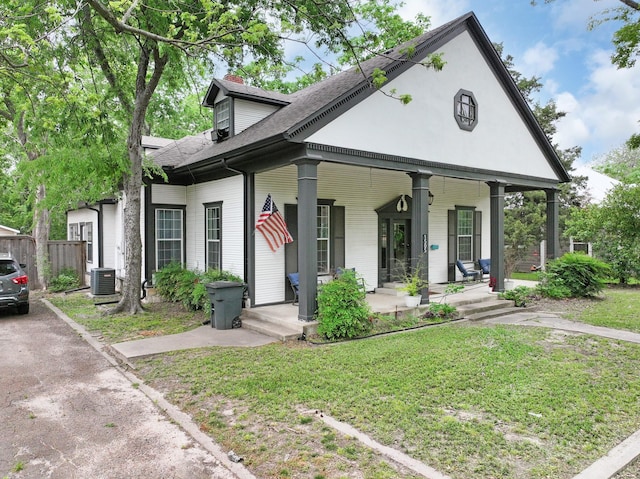 1505 Bois D Arc St, Commerce, TX 75428 - view of front of home with covered porch, a chimney, central AC, and roof with shingles