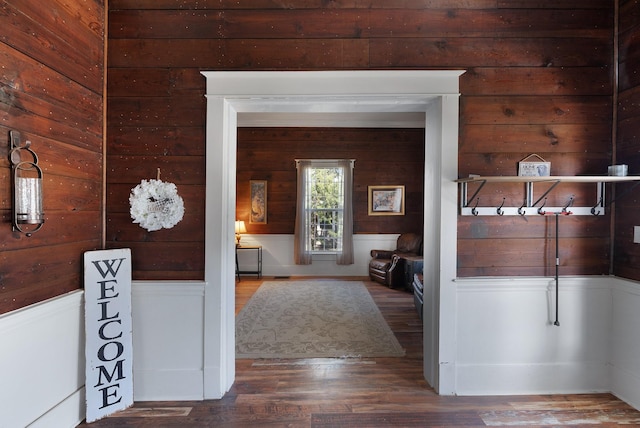 corridor with dark wood finished floors and wooden walls