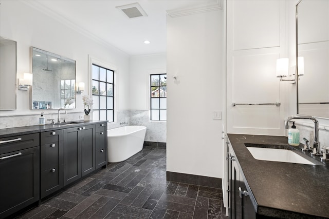 full bathroom with a wainscoted wall, visible vents, vanity, a freestanding bath, and crown molding