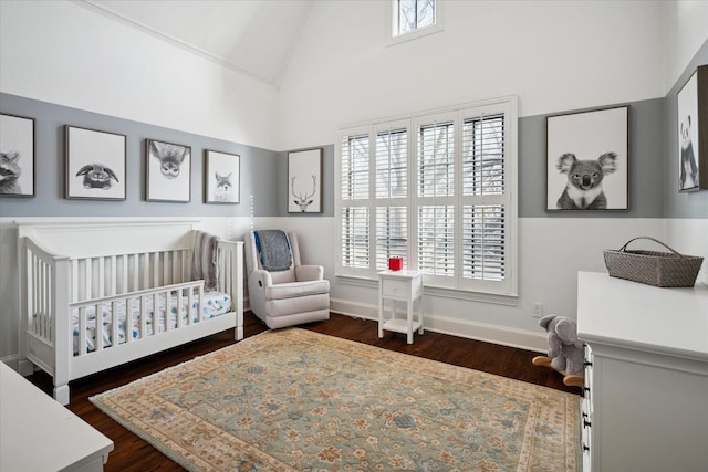 bedroom with dark wood-type flooring, multiple windows, and a crib