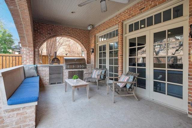 view of patio / terrace with an outdoor kitchen, a ceiling fan, grilling area, fence, and french doors