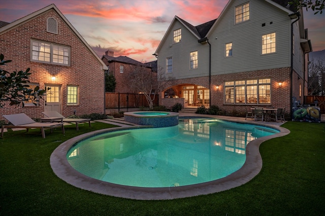 view of swimming pool with a yard, a patio, fence, and a pool with connected hot tub