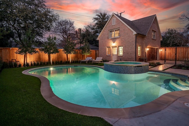 view of pool featuring a lawn, a fenced backyard, and a pool with connected hot tub