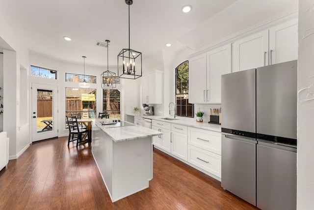 kitchen featuring freestanding refrigerator, dark wood-style flooring, a healthy amount of sunlight, and a sink