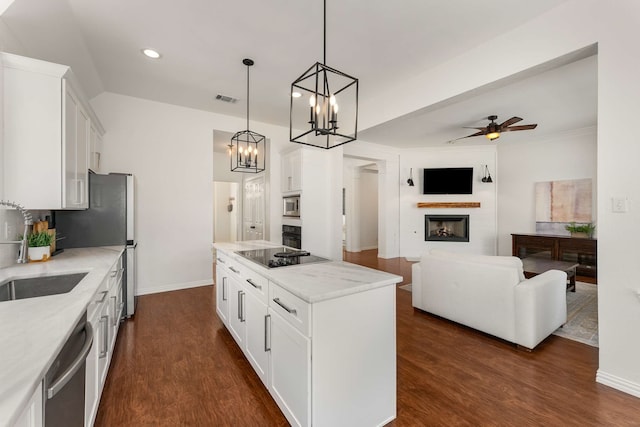 kitchen with visible vents, dark wood-type flooring, black appliances, a fireplace, and a sink