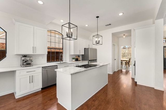 kitchen with a kitchen island, a sink, visible vents, appliances with stainless steel finishes, and dark wood finished floors