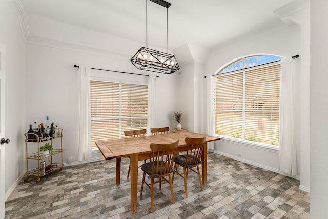 dining room featuring brick floor, crown molding, and baseboards