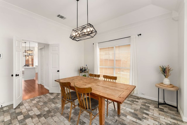 dining space featuring baseboards, visible vents, brick floor, crown molding, and a notable chandelier