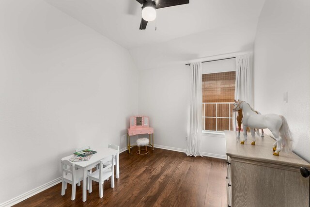 bedroom featuring a ceiling fan, wood walls, baseboards, and wood finished floors