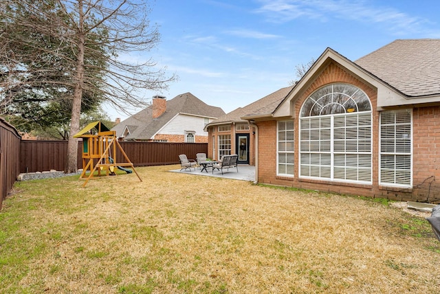 view of yard with a patio area, a fenced backyard, and a playground