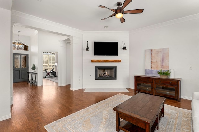 living room with a fireplace, a ceiling fan, wood finished floors, and ornamental molding