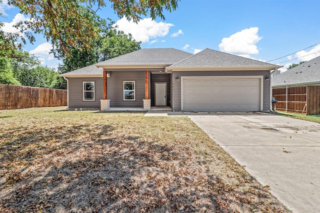 view of front facade with an attached garage, fence, driveway, roof with shingles, and a front lawn