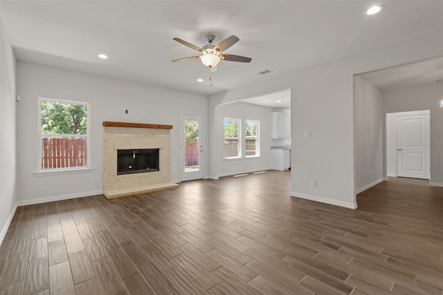 unfurnished living room with visible vents, a ceiling fan, dark wood-type flooring, a fireplace, and recessed lighting